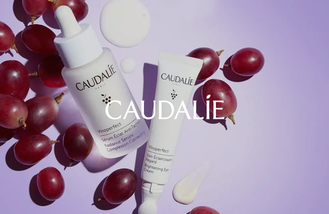 Caudalie skincare products surrounded by red grapes, embodying the benefits of nature and luxury.