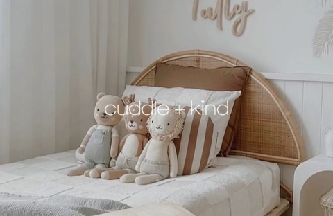 Collection of handcrafted wool plush toys by Cuddle + Kind in a child’s room, symbolizing softness, kindness, and quality craftsmanship.