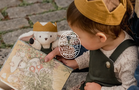 Child playing with a cloth doll by Hazel Village, surrounded by plush toys, embodying imagination and childlike play.