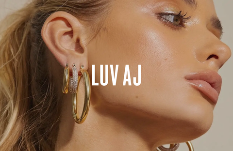 Woman wearing gold earrings by Luv Aj, representing a modern and elegant style.