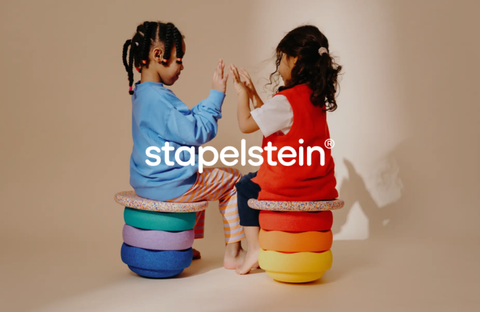 Two children playing with colorful, stackable modules by Stapelstein, promoting dynamic and educational play.